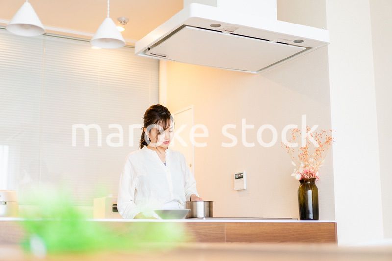 おうちのキッチンで料理をする主婦