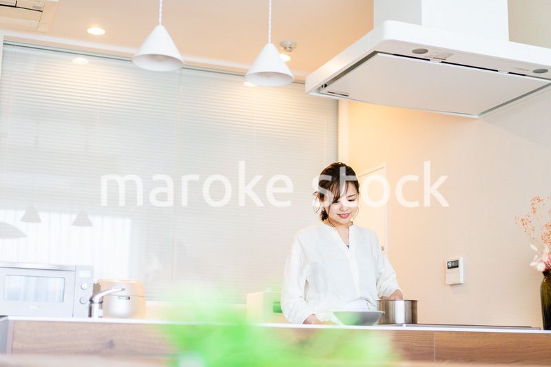 おうちのキッチンで料理をする主婦