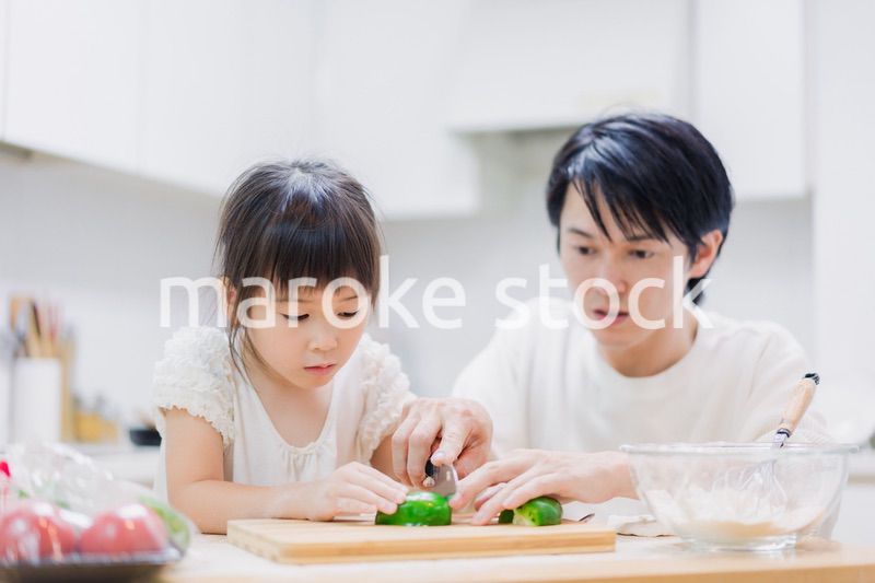 パパと一緒にクッキングをする小さな女の子