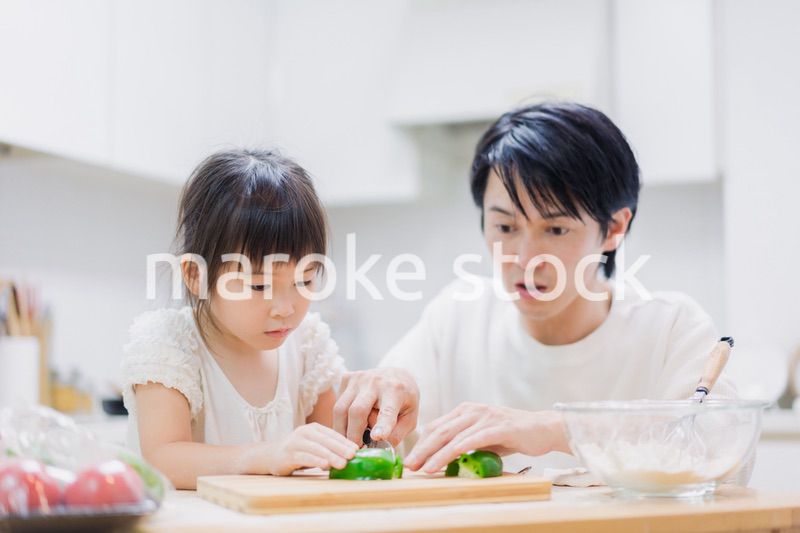 パパと一緒にクッキングをする小さな女の子