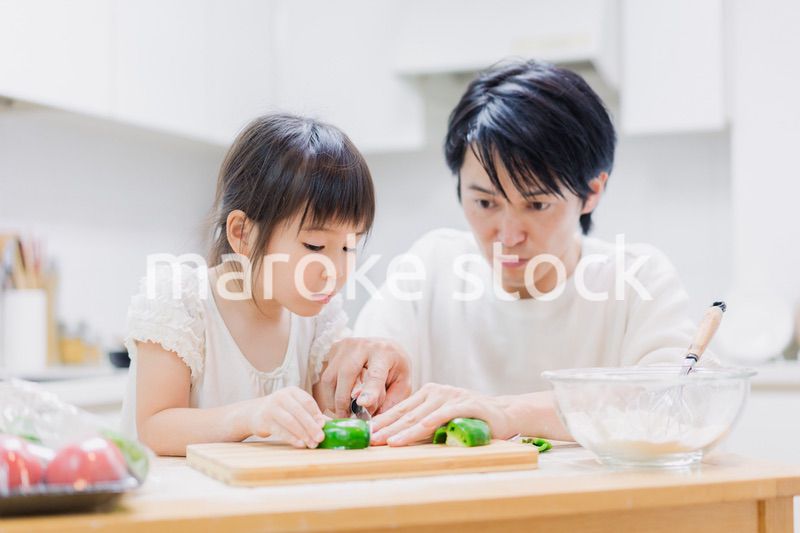 パパと一緒にクッキングをする小さな女の子