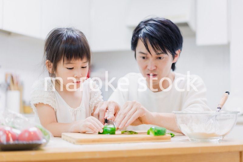 パパと一緒にクッキングをする小さな女の子