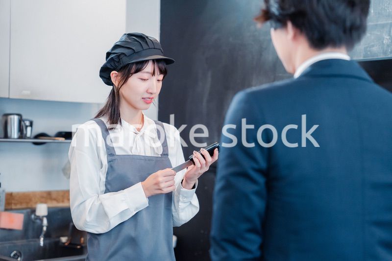 カフェでクレジットカード決済をする男性客