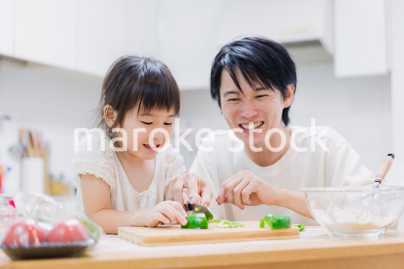 パパと一緒にクッキングをする小さな女の子