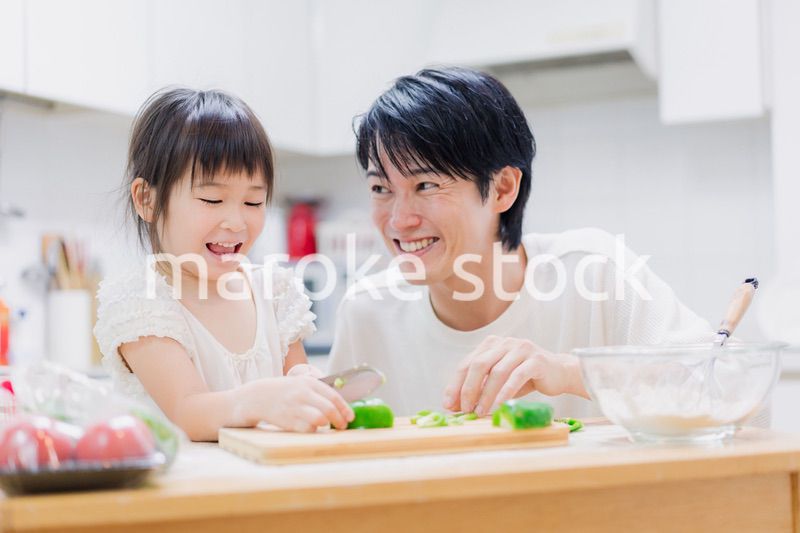 パパと一緒にクッキングをする小さな女の子
