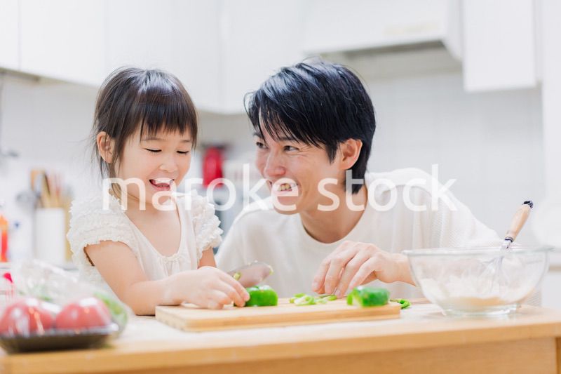 パパと一緒にクッキングをする小さな女の子