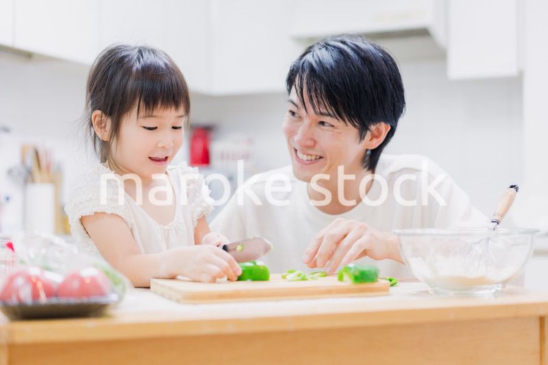 パパと一緒にクッキングをする小さな女の子