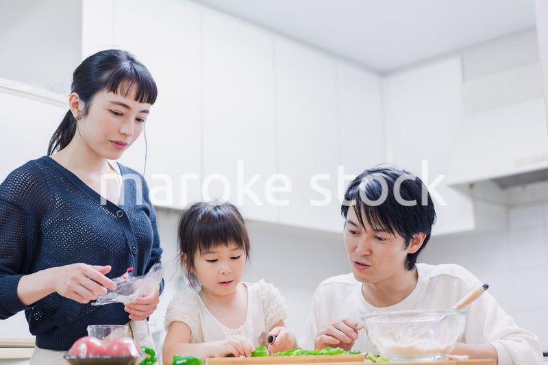 子供と一緒にクッキングをする家族