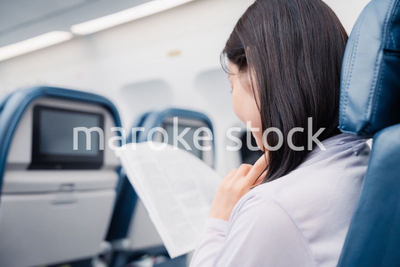 飛行機で出張をするキャリアウーマン