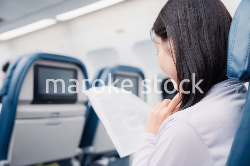 飛行機で出張をするキャリアウーマン