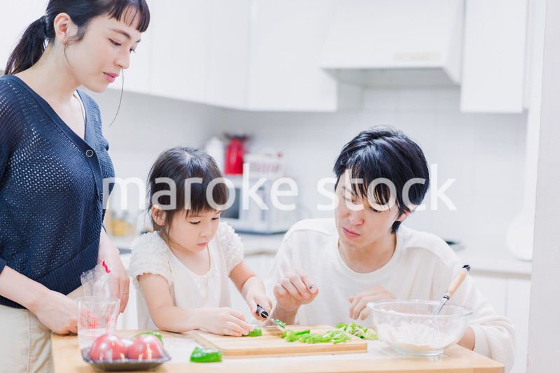 子供と一緒にクッキングをする家族
