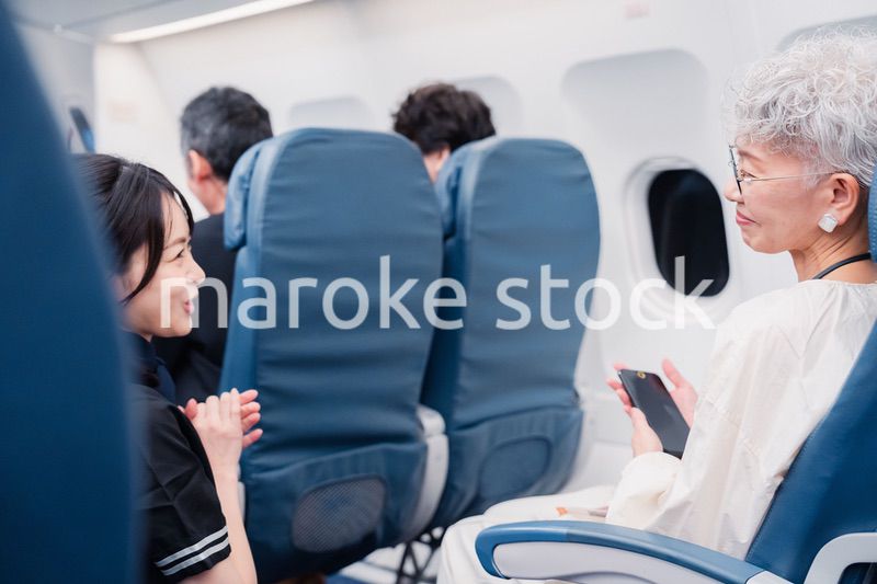 高齢の乗客を案内するキャビンアテンダント