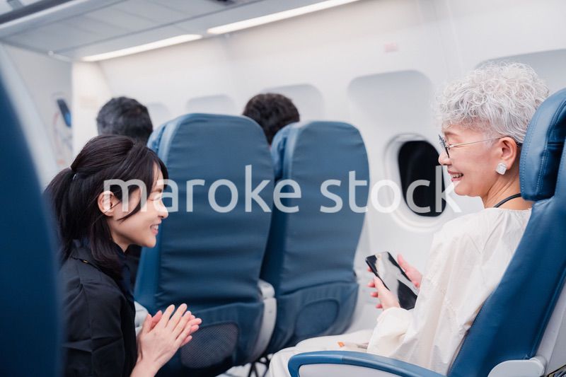 高齢の乗客を案内するキャビンアテンダント