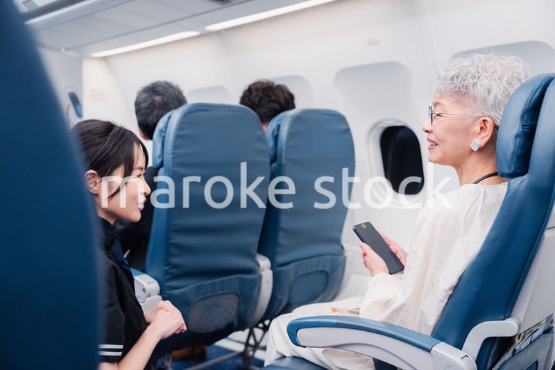 高齢の乗客を案内するキャビンアテンダント