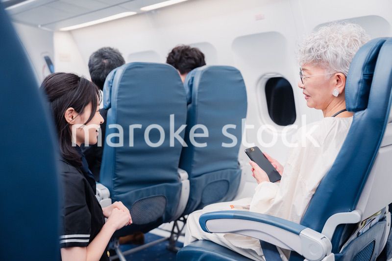 高齢の乗客を案内するキャビンアテンダント