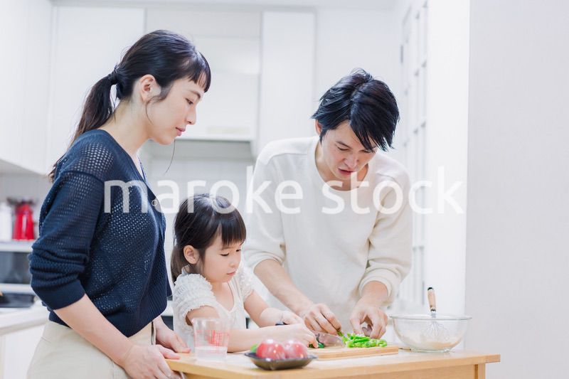 子供と一緒にクッキングをする家族