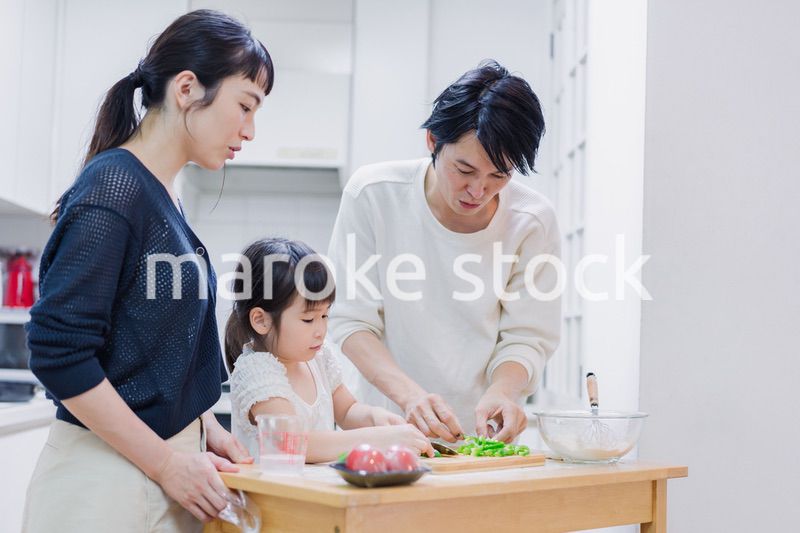 子供と一緒にクッキングをする家族