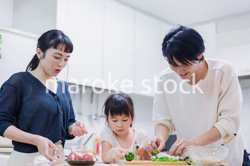 子供と一緒にクッキングをする家族