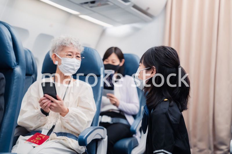 マスクをしてお客様の案内をするキャビンアテンダント