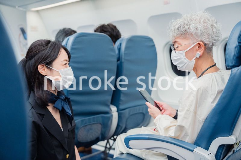マスクをして機内サービスをする客室乗務員