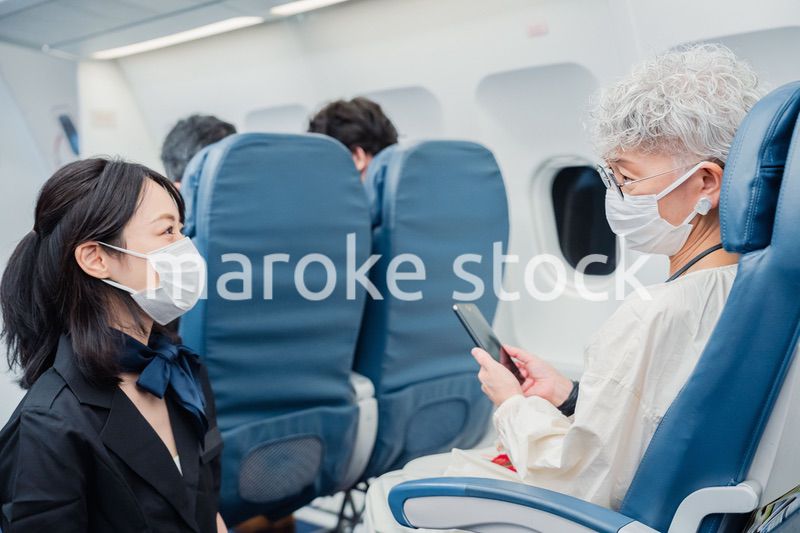 マスクをして機内サービスをする客室乗務員