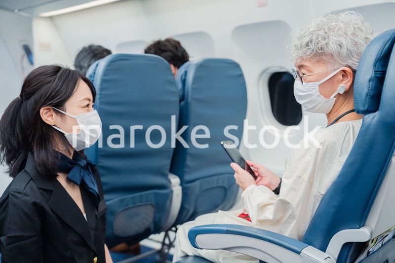 マスクをして機内サービスをする客室乗務員