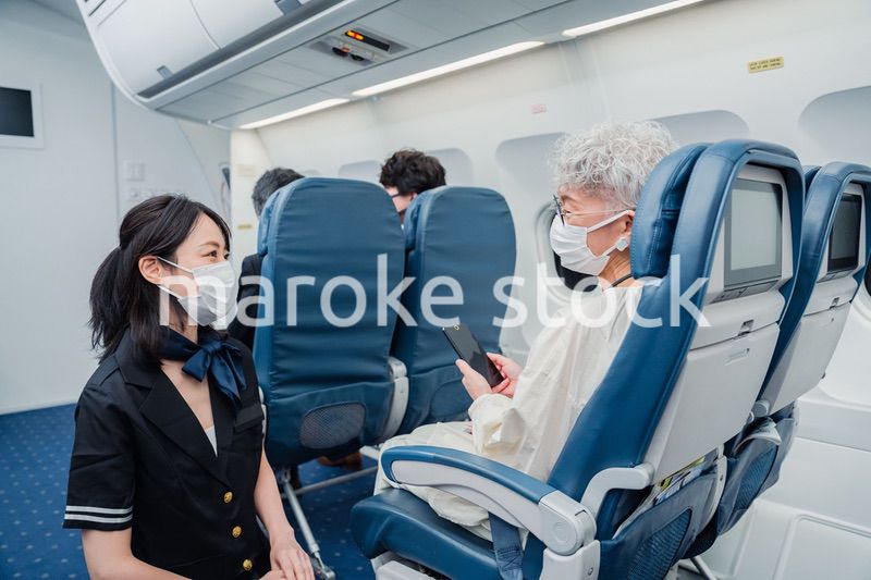 マスクをして機内サービスをする客室乗務員
