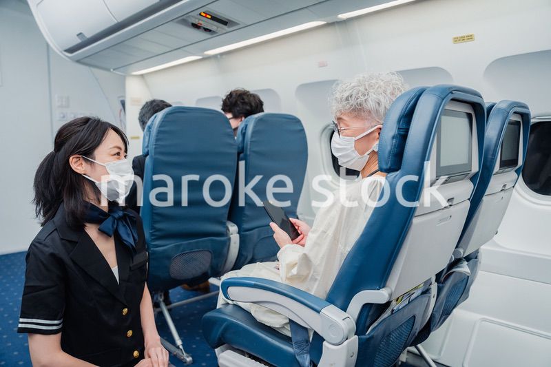 マスクをして機内サービスをする客室乗務員