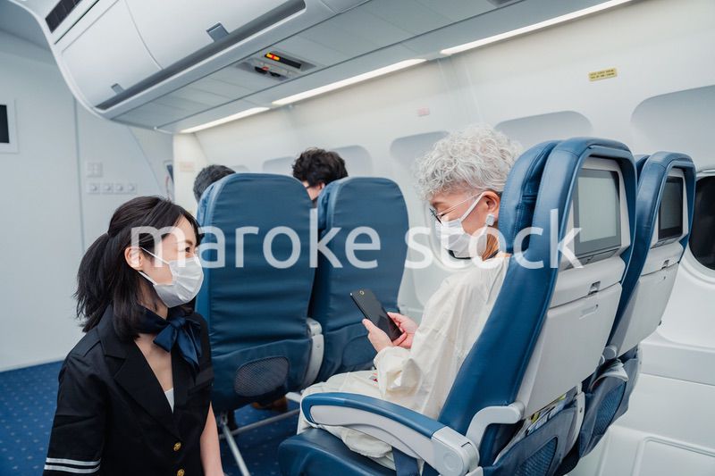 マスクをして機内サービスをする客室乗務員
