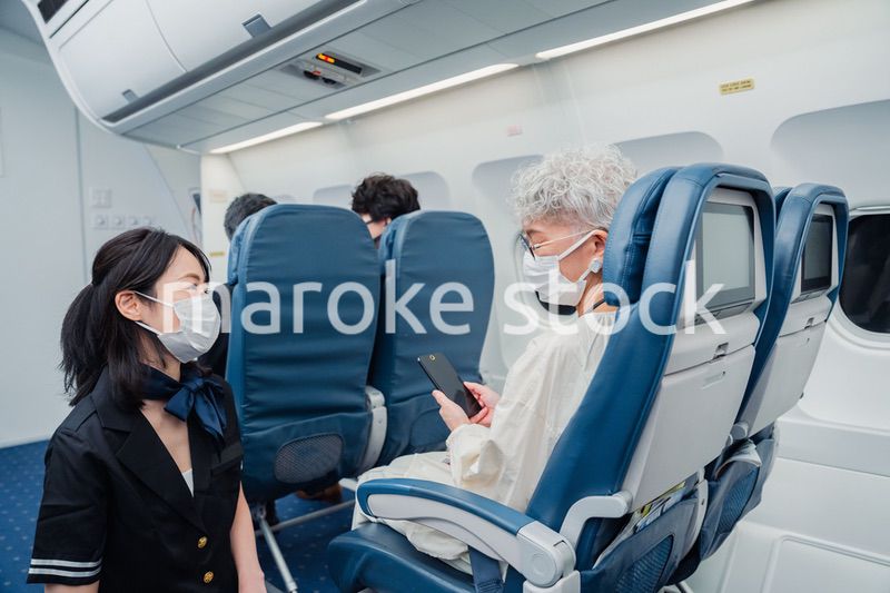 マスクをして機内サービスをする客室乗務員