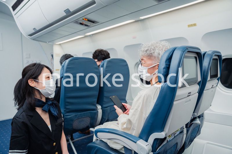 マスクをして機内サービスをする客室乗務員