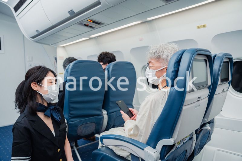 マスクをして機内サービスをする客室乗務員