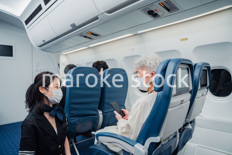 マスクをして機内サービスをする客室乗務員