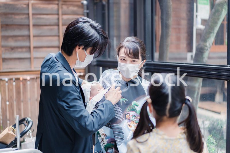 赤ちゃんとお宮参りをする家族