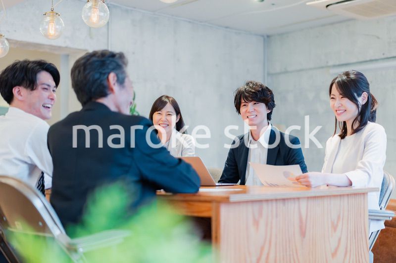 笑顔で会議をするビジネスパーソン
