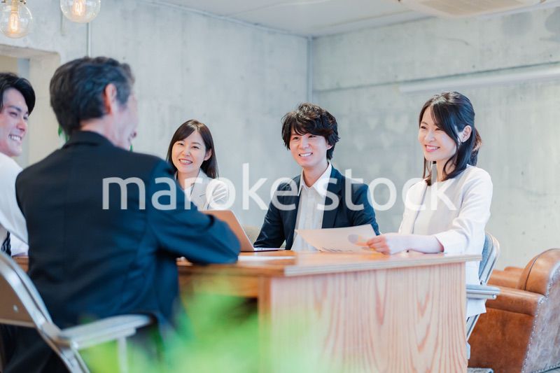 笑顔で会議をするビジネスパーソン