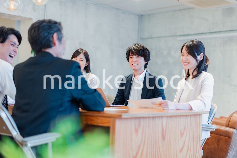 笑顔で会議をするビジネスパーソン