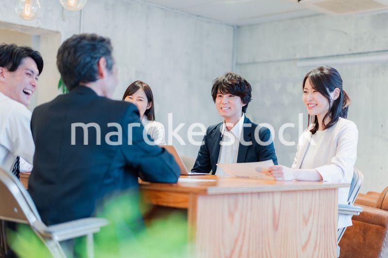 笑顔で会議をするビジネスパーソン