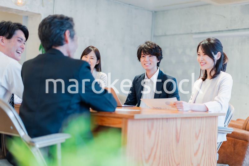 笑顔で会議をするビジネスパーソン