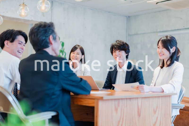 笑顔で会議をするビジネスパーソン