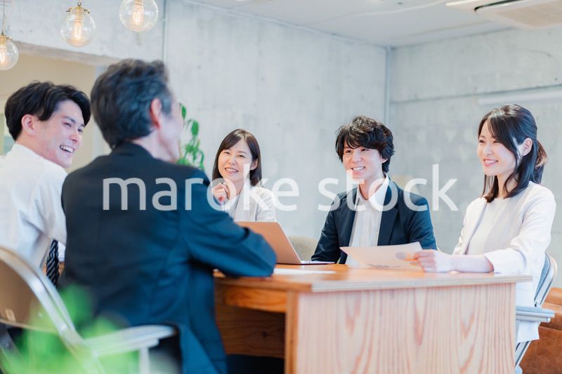 笑顔で会議をするビジネスパーソン