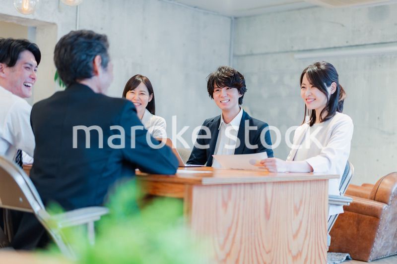 笑顔で会議をするビジネスパーソン