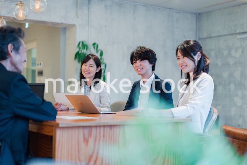 笑顔で会議をするビジネスパーソン