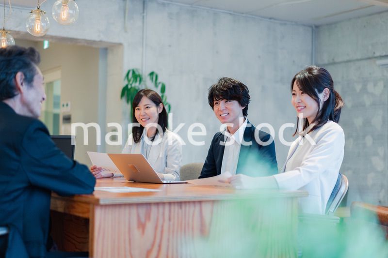 笑顔で会議をするビジネスパーソン