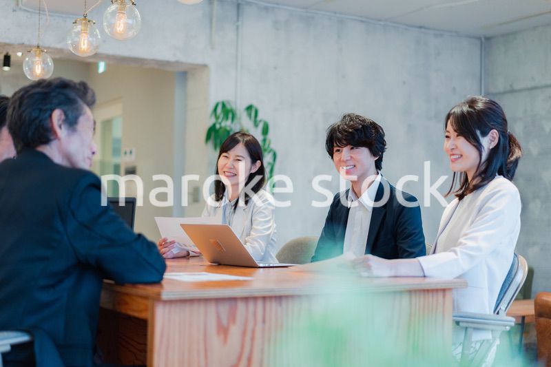 笑顔で会議をするビジネスパーソン