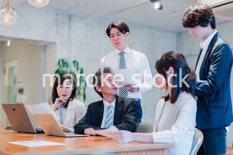 明るいオフィスに勤務をするビジネスパーソン