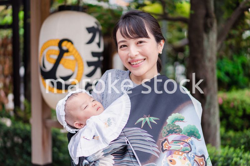 外で赤ちゃんを抱っこするお母さん