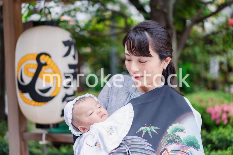 外で赤ちゃんを抱っこするお母さん