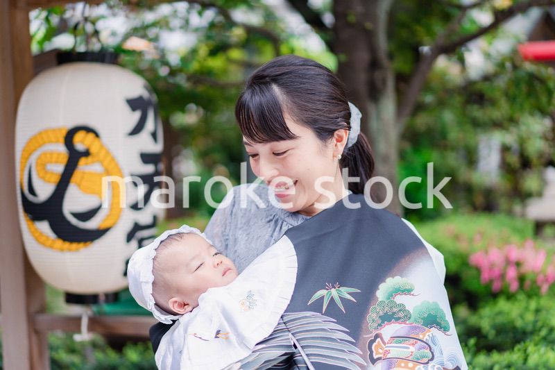 外で赤ちゃんを抱っこするお母さん