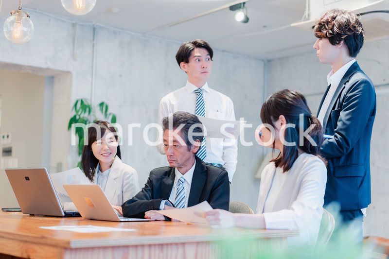 明るいオフィスに勤務をするビジネスパーソン